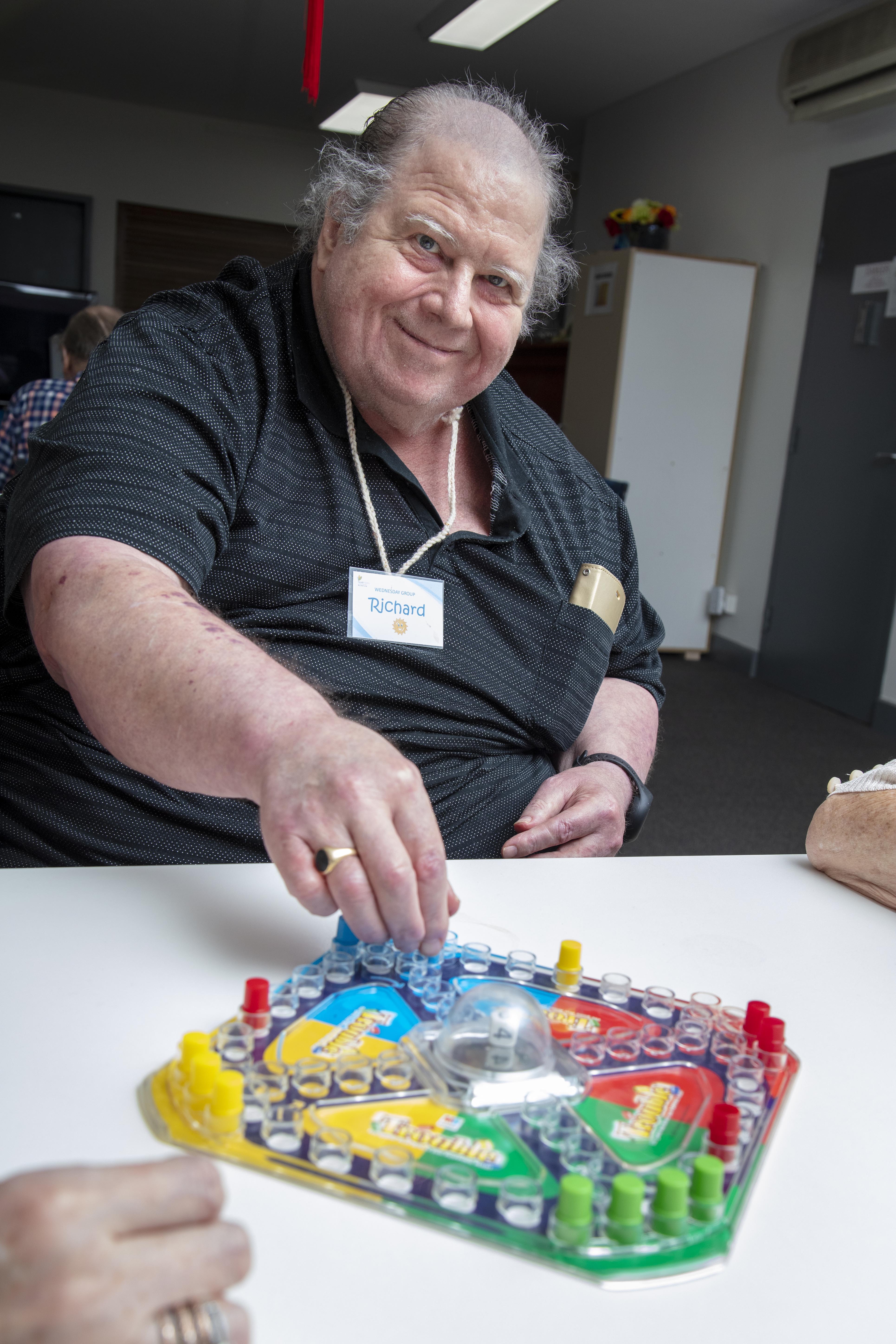 A Connect Well participant plays a board game